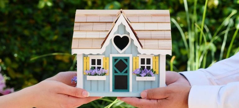Couple holding a wooden house model