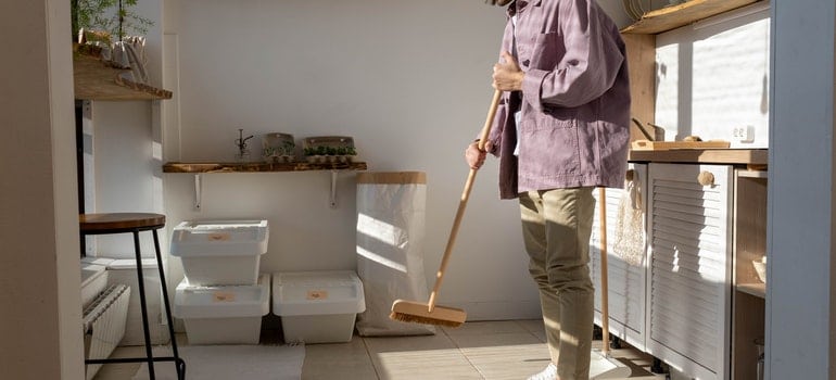 a man standing and holding a cleaning brush