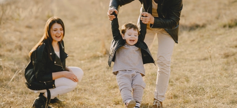 mother and father playing football with their son