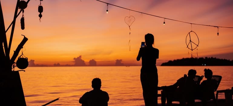 people watching sunset on the beach