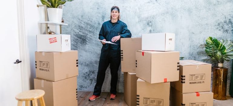 A man standing next to the cardboard boxes