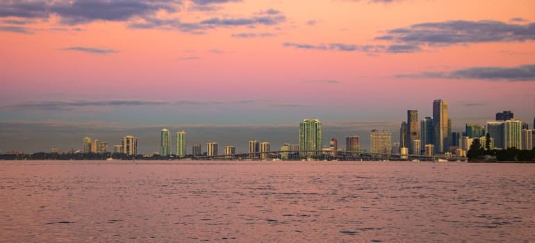 buildings in sunset seen from the water from far away