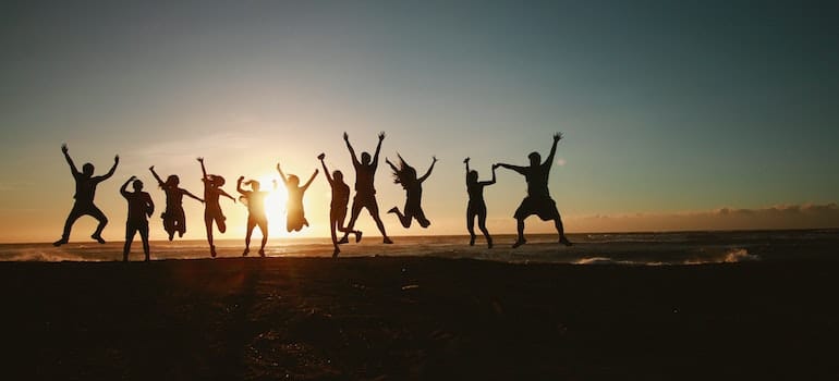 people jumping on the beach in sunset