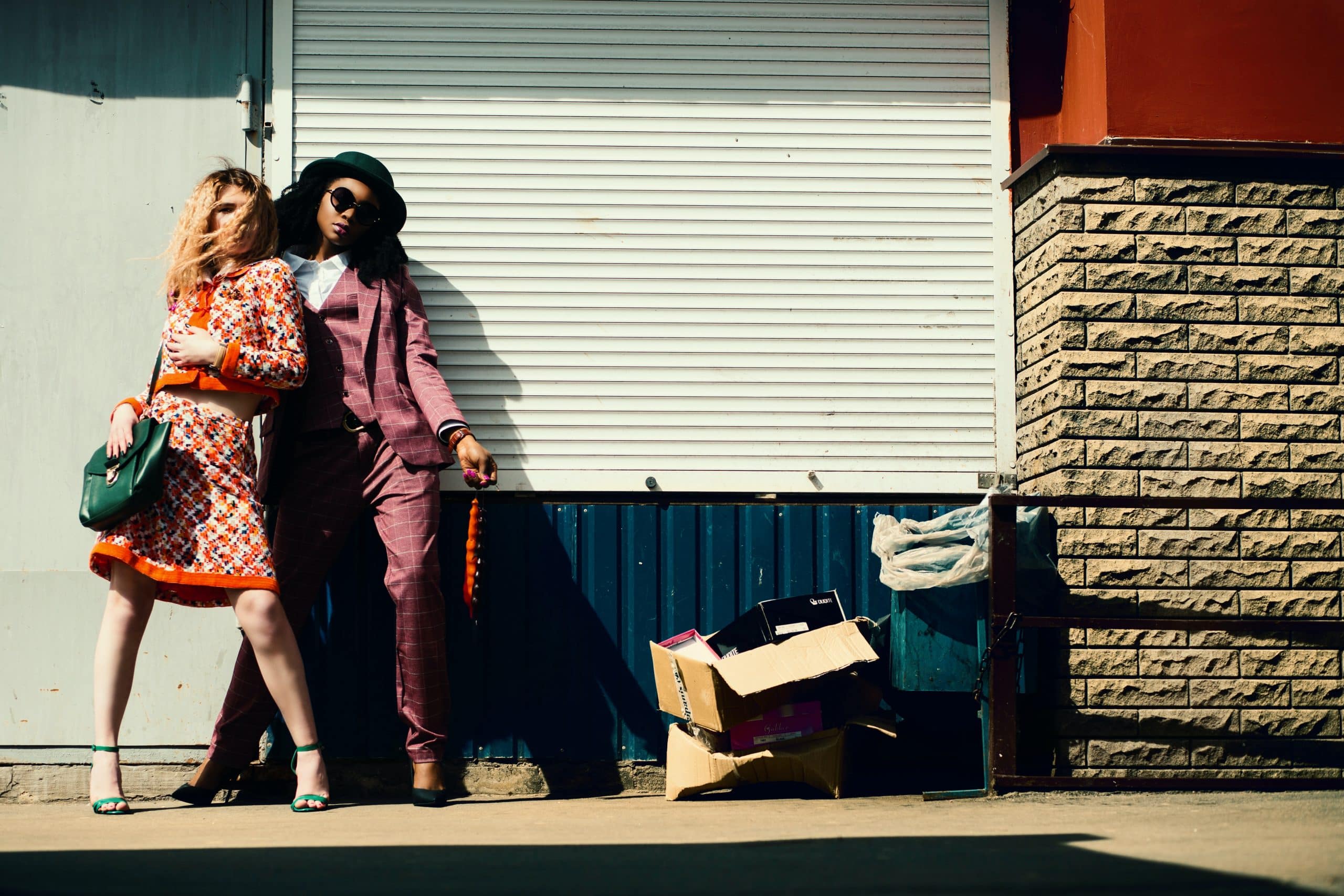 two girls dressed and posing next to the wall