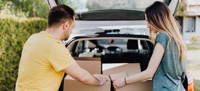 LA couple loading a car with boxes