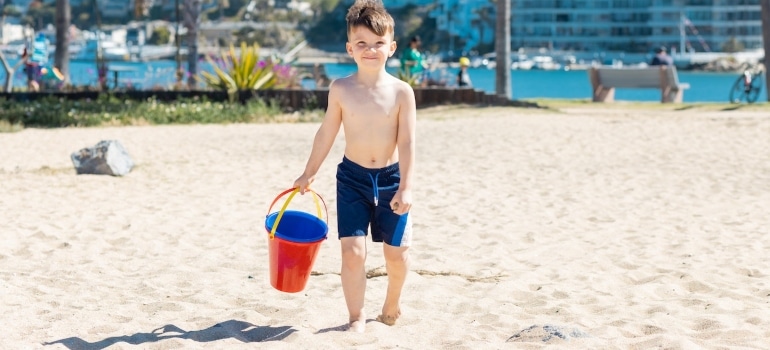 A boy on the beach with a bucket in one of the places in Florida to move to after a divorce