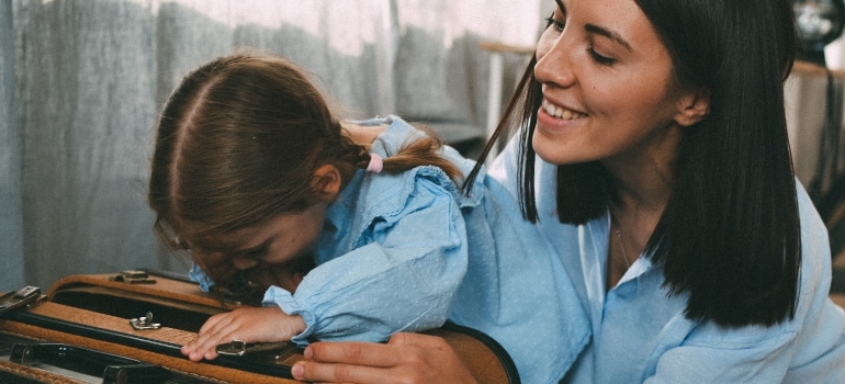 mom and daughter holding a suitcase