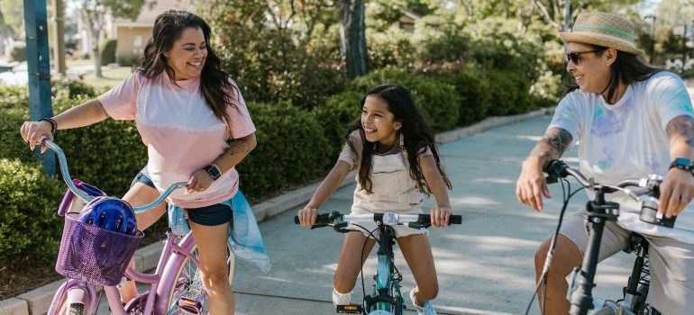 two people and a child riding a bike