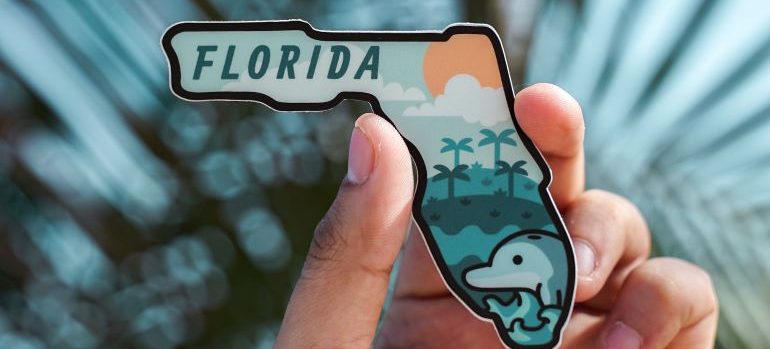 a person holding a magnet with the word Florida on it