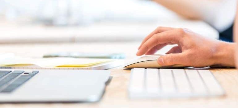 a silver keyboard and a hand on a mouse ready to inform about your commercial relocation in Florida