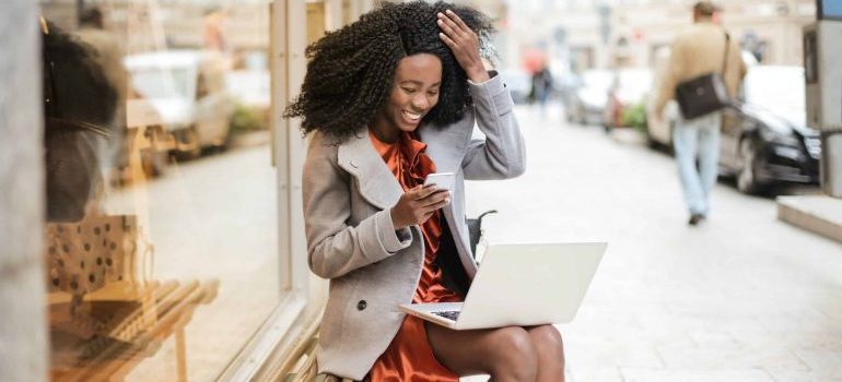 A woman sitting on a bench and checking her cellphone