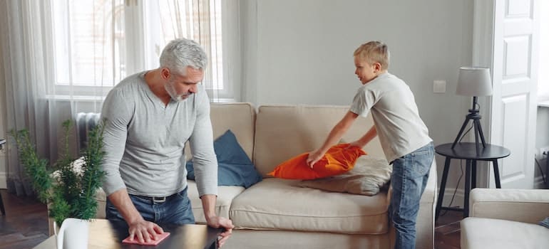 father and son cleaning a living room before moving