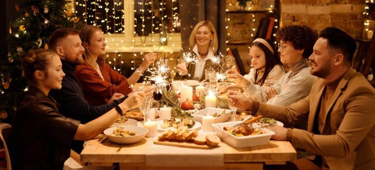 People sitting by the table and eating dinner