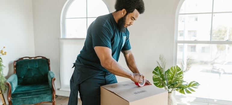 A man holding a packing tape