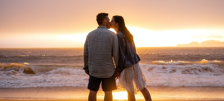 Couple happy on the beach after deciding which of small cities in Florida for aspiring artists they are going to live in