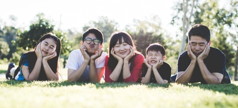 The family is lying on the grass after moving to one of the best Florida towns for first time home buyers.