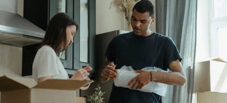 two people packing the kitchen for moving