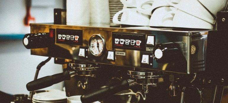 An espresso machine with white mugs prepared for moving your coffee shop in Boca Raton.