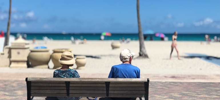 Couple relaxing on the beach after moving from Miami to Boca Raton.