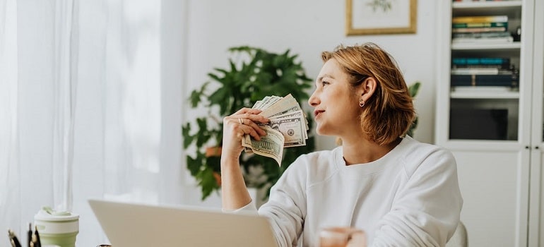 A girl holding a fan of money, planning a move.