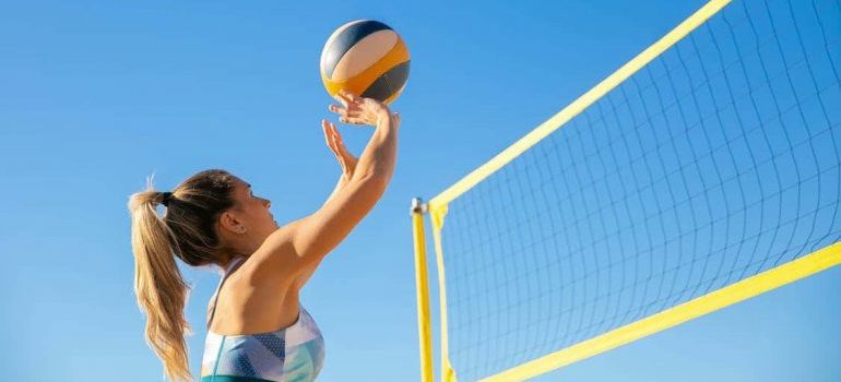 A woman playing volleyball during her family fun in Hallandale Beach