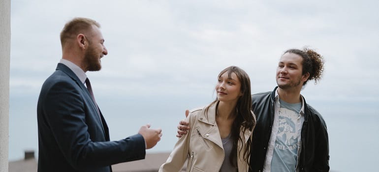 a couple talking to a real estate agent