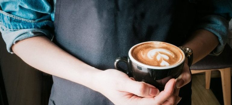 A woman holding a mug of coffee.