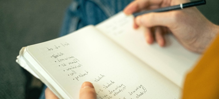 A person writing down tips in a notebook.