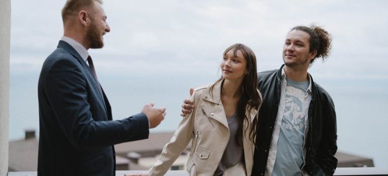 A moving agent talking to a young couple.