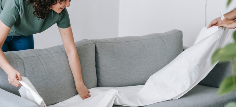 Couple packing sofa with blankets.