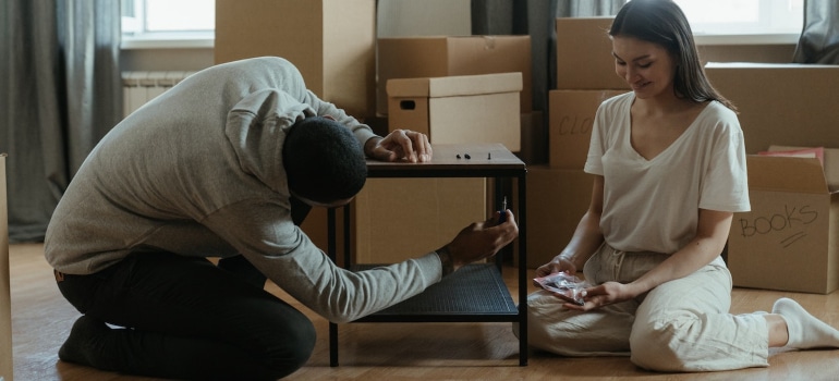 A couple preparing furniture for moving.