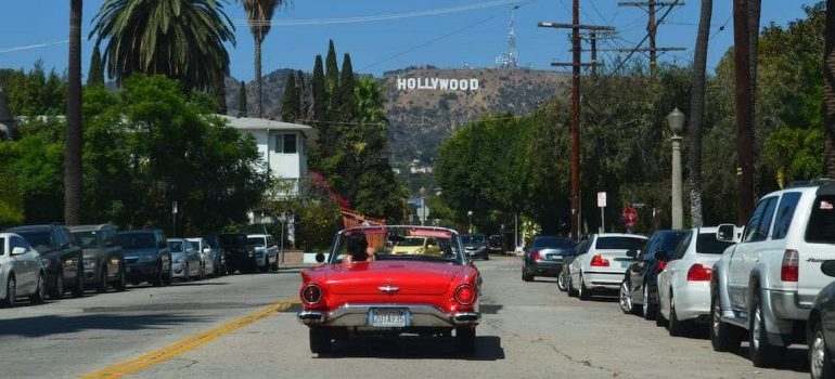 A woman driving a red car in Hollywood.