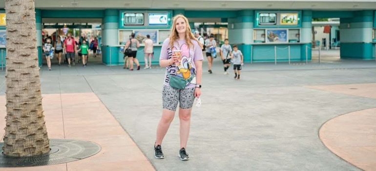 A young woman posing in front of the Hollywood studio and thinking about moving to Hollywood this spring.