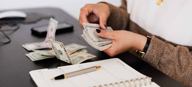 Woman counting money before investing in rental property in Miami in 2023.