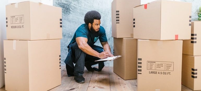 Person is checking cardboard moving boxes.