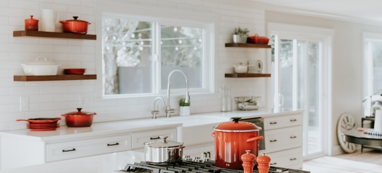 A clean white and red kitchen is a solution to a cluttered home in Miami.