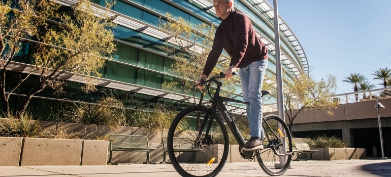 A senior riding a bike and thinking about available and suitable retirement communities in Florida