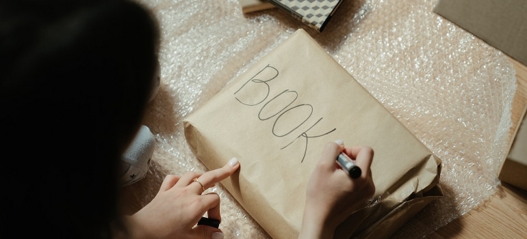 A person ready to pack a hobby room for moving while holding a pen