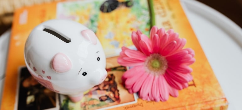 A piggy bank beside the flower