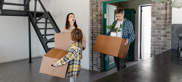 a family carrying boxes