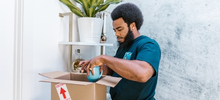 A man packing a ceramic mug