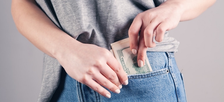 A person holding money in the pocket