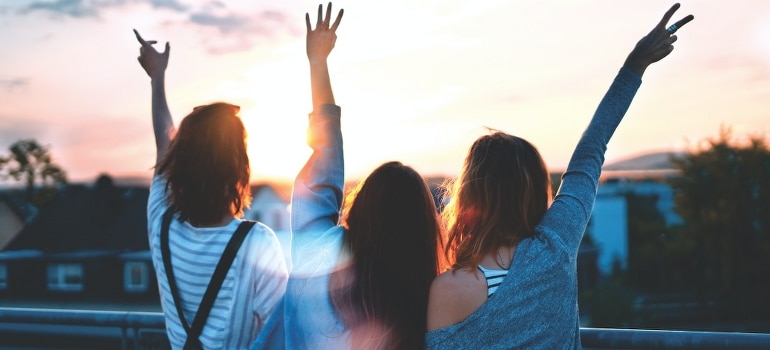 Women lifting their hands after the move to Wilton Manors