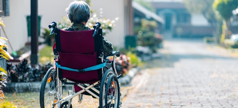 A person in a wheelchair thinking about packing and moving tips for people with disabilities.