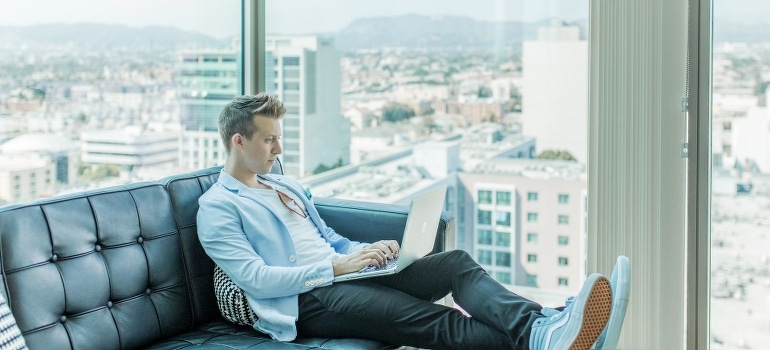 A man who is about to invest in real estate in Pompano Beach uses a laptop.