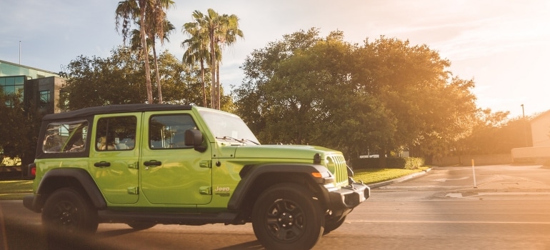 A green vehicle on the road.