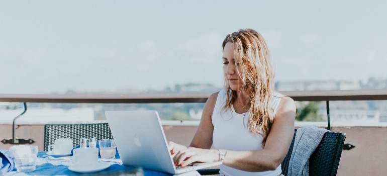 A woman using a laptop to find the best places in Florida for remote workers.
