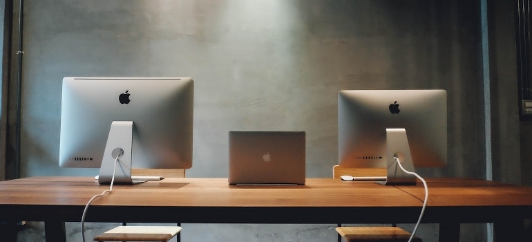 Two silver Imac on the table