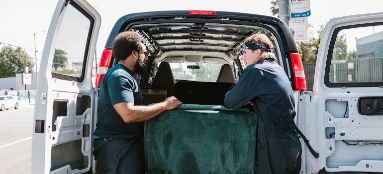 Two movers load the furniture onto a van to make your Tampa relocation a breeze.