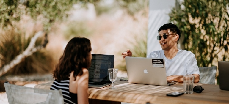 A man and woman sitting outdoors and talking about the best places in Florida for remote workers. 
